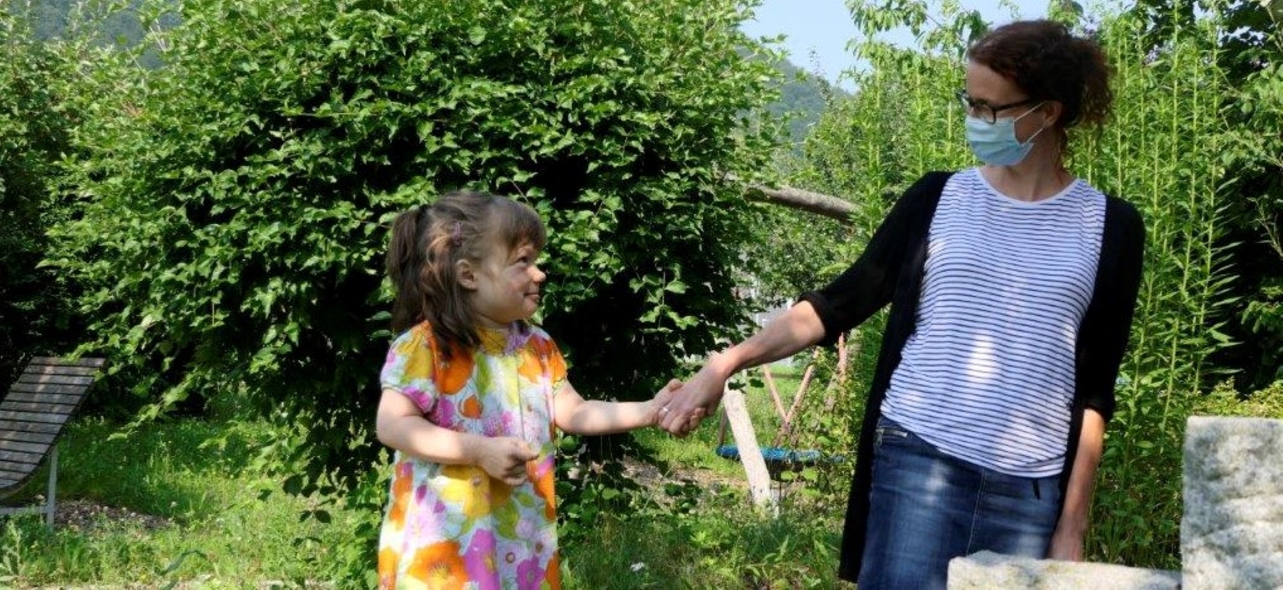 Zwei Personen im Garten halten sich an den Händen